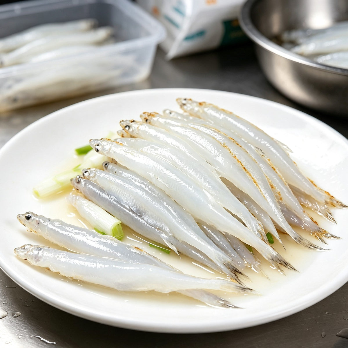 Fresh whitebait icefish on a plate with spring onion